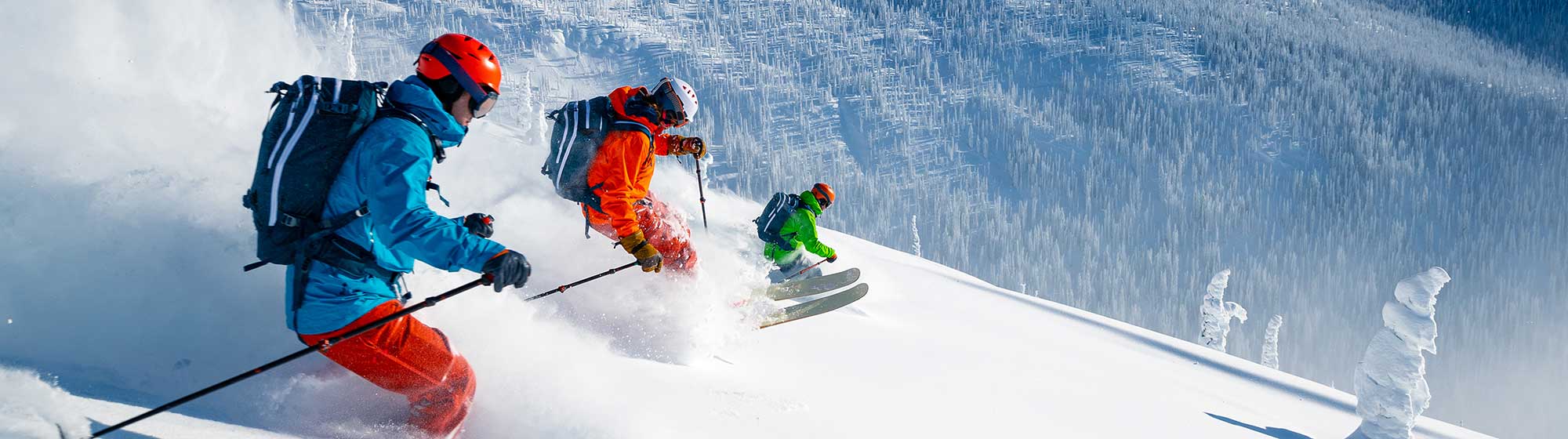 Des skieurs descendent la montagne dans le niege poudreuse