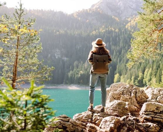 une femme avec un sac à dos regarde le lac