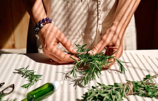 Mains préparant des herbes naturelles sur une table