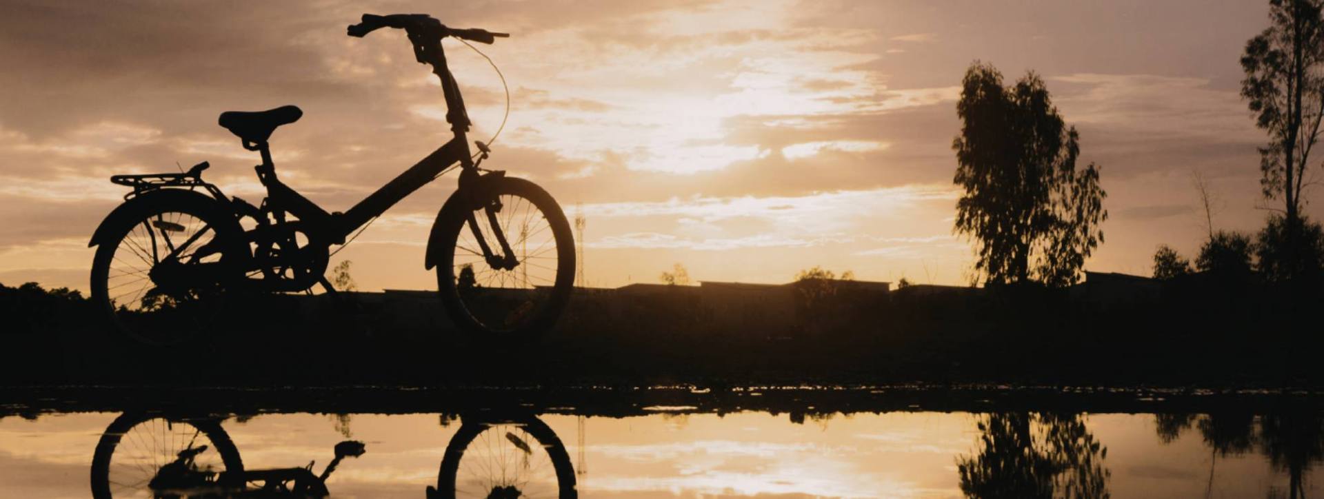 Un vélo au bord de l'eau au couché du soleil