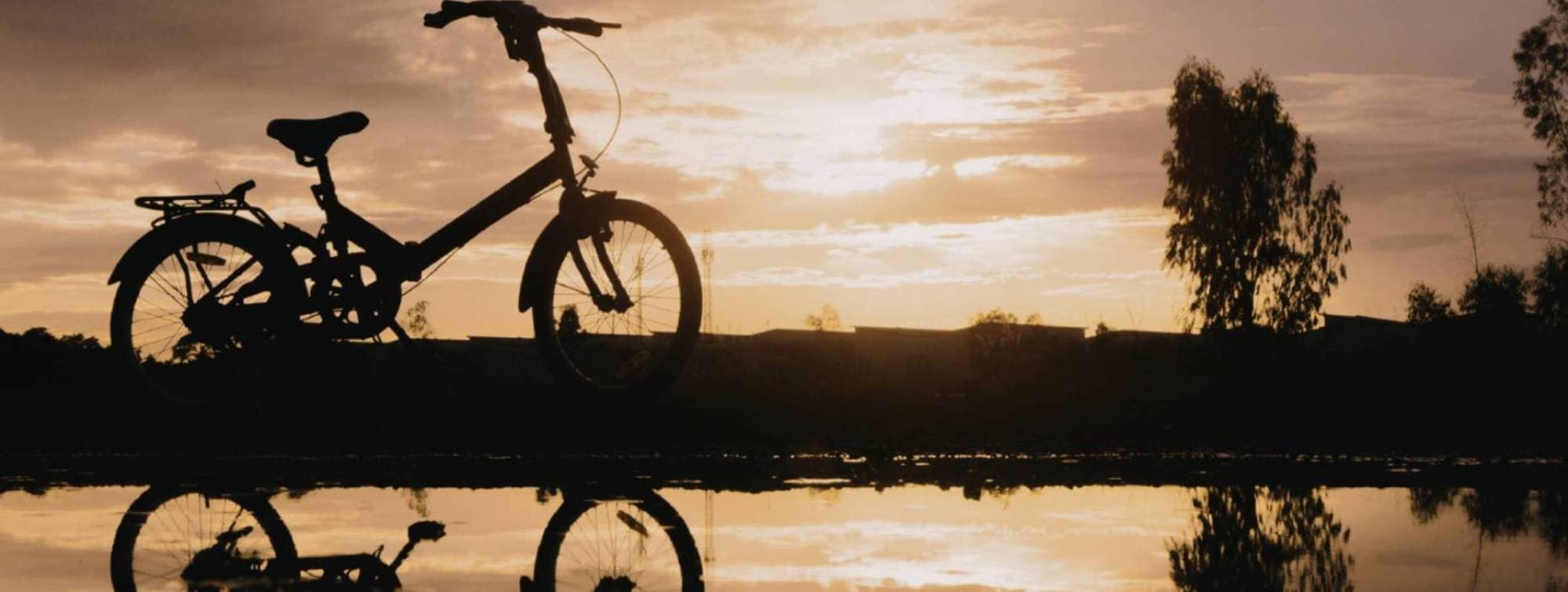 Un vélo au bord de l'eau au couché du soleil