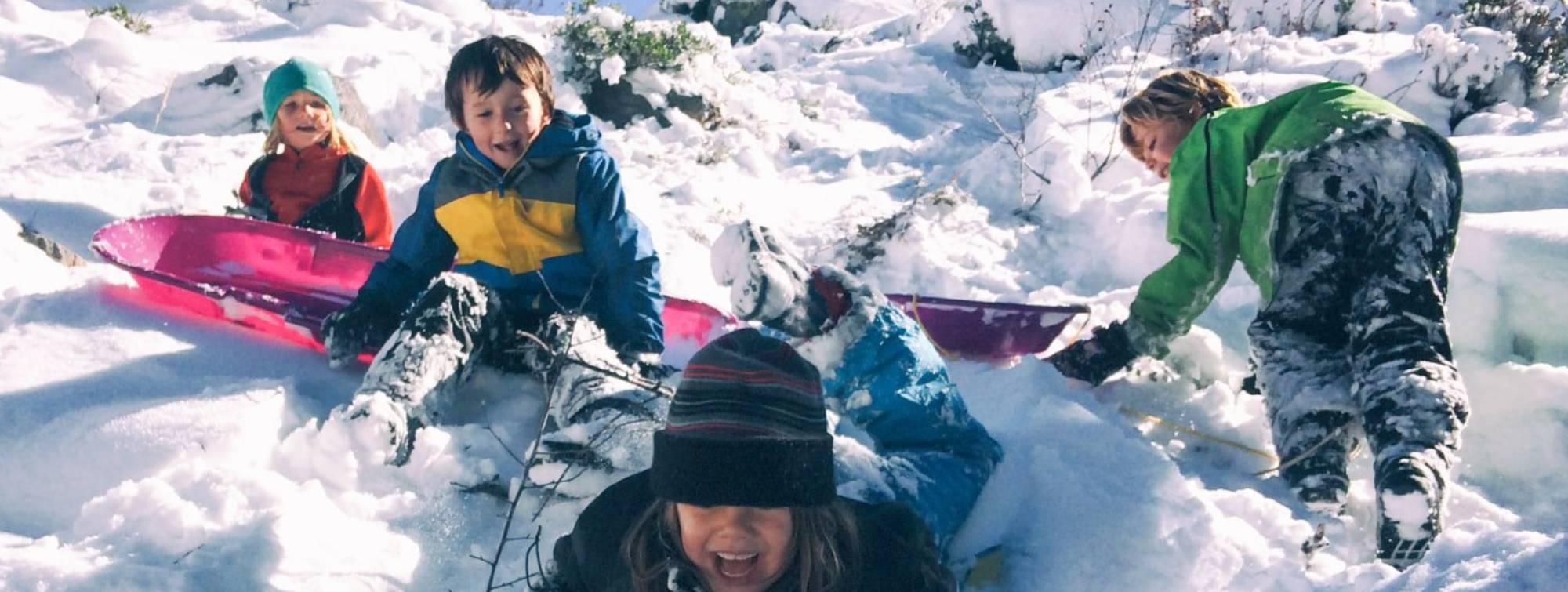  Des enfants font de la luge sur la neige 