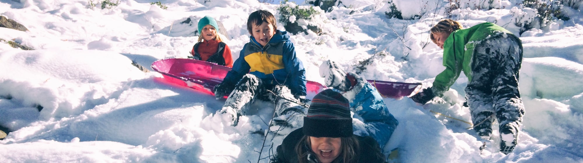  Des enfants font de la luge sur la neige 