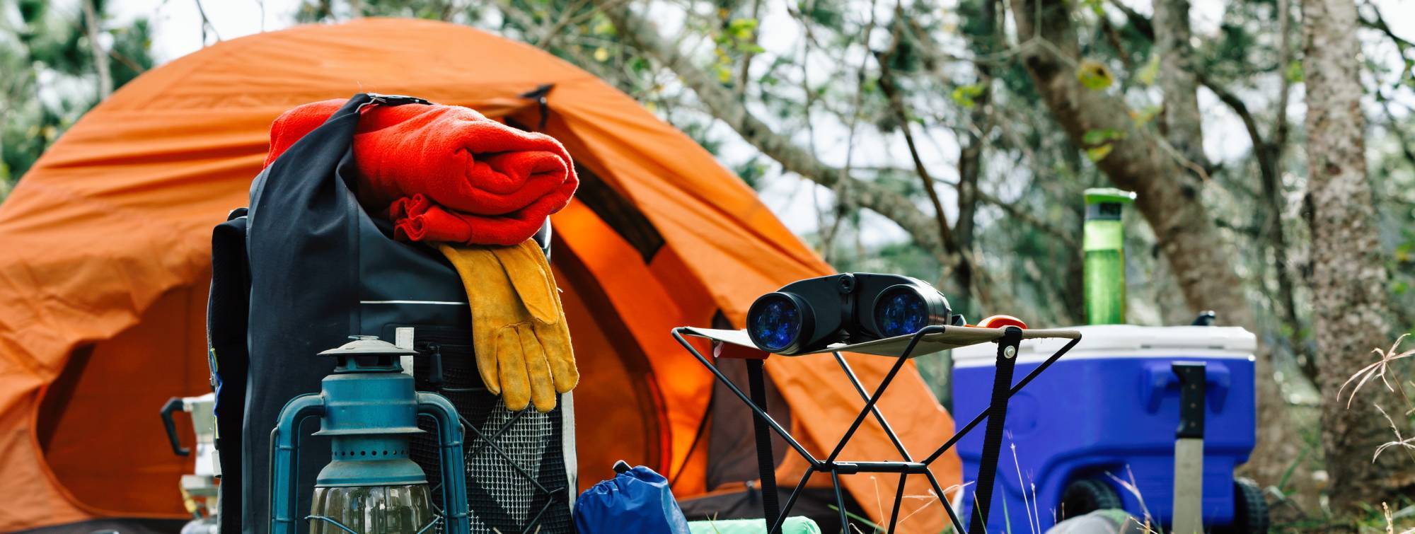 Équipements de camping et accessoires disposés près d’une tente