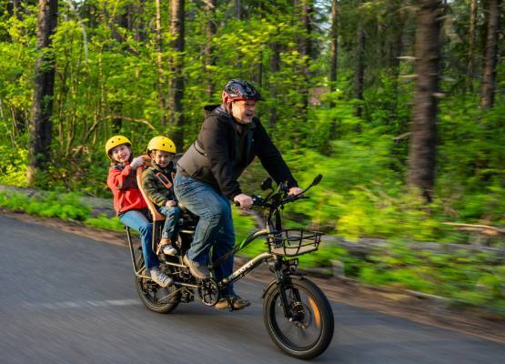 Un père et ses deux enfants sur un vélo