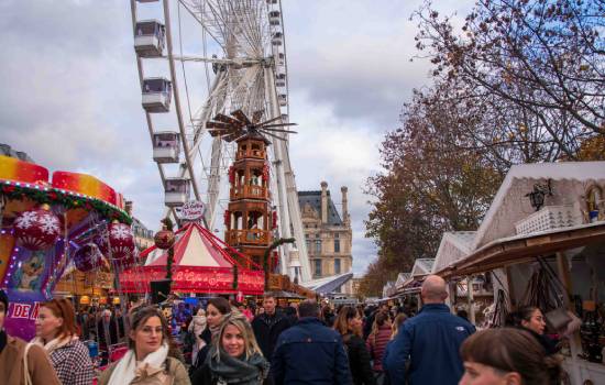 Un marché de Noël avec des visiteurs et une grande roue