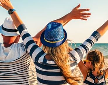 Une famille qui lèvent les bras sur la plage
