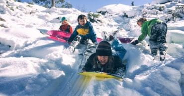  Des enfants font de la luge sur la neige 