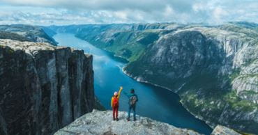 Un couple arrivé en haut d'un sommet face à une belle vue