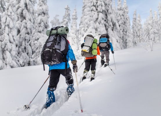Des skieurs en randonnée face à une pente