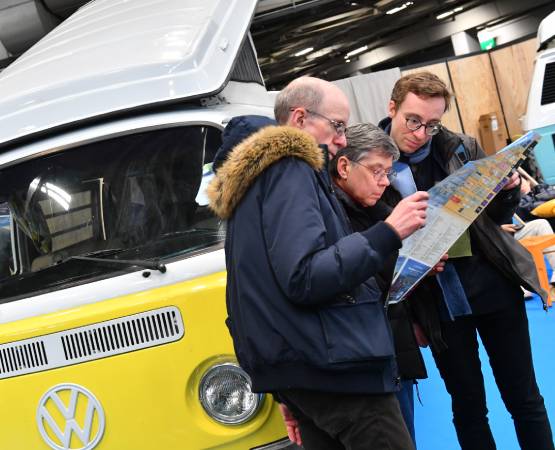 3 personnes qui regardent un plan