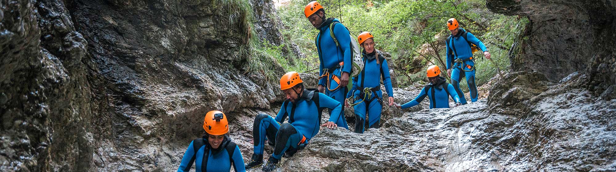 Des jeunes font du canyoning sur un courant d'eau en montagne