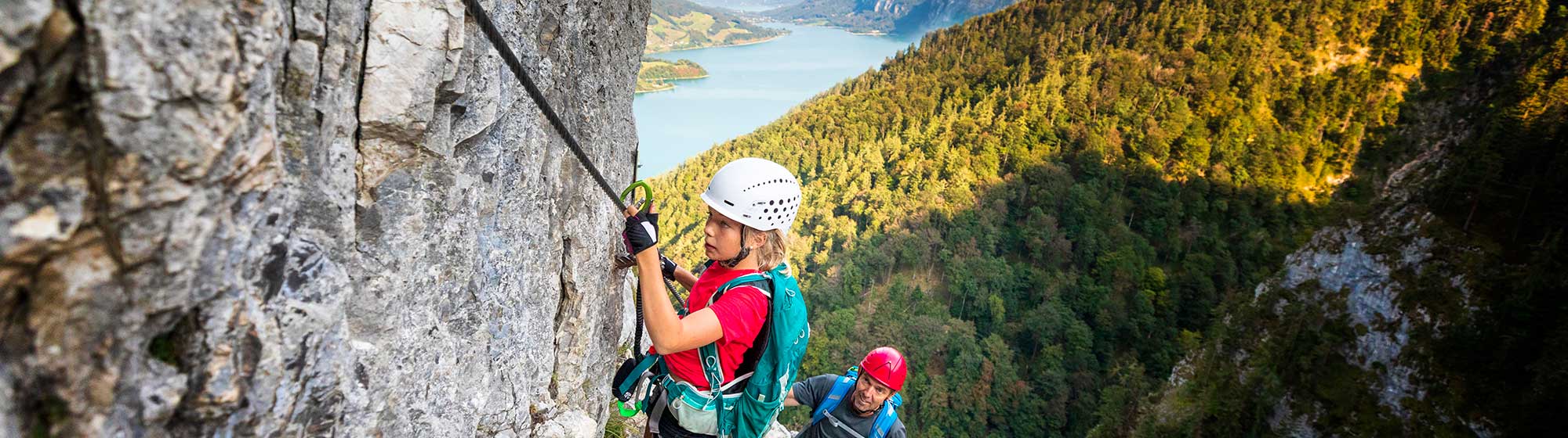 Un père fait de l'escalade en montagne avec sa fille
