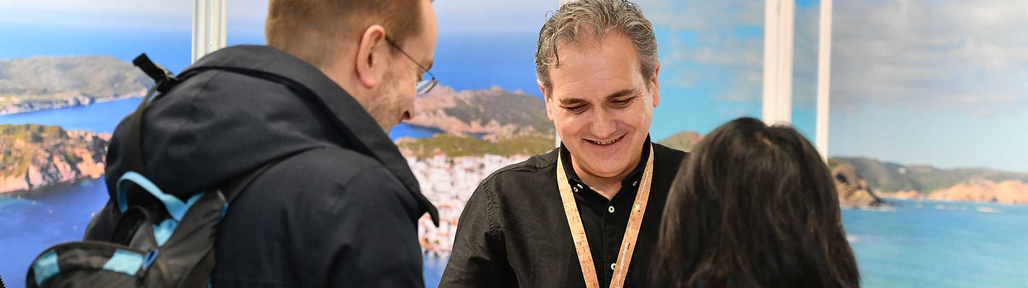 Des visiteurs se renseignent auprès d'un exposant