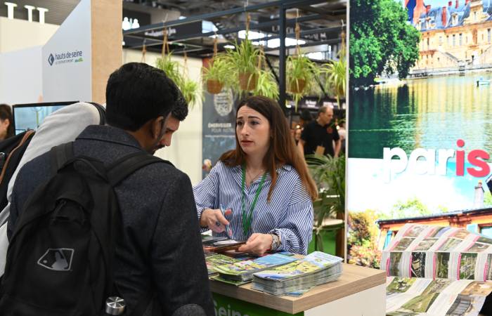 des hommes qui parlent avec une femme sur son stand