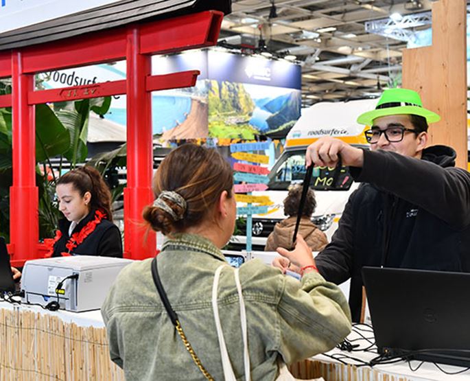 Un hôte remet le badge d'un exposant