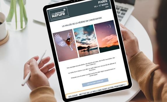 Une personne regardant sa tablette avec une newsletter Destinations Nature. 