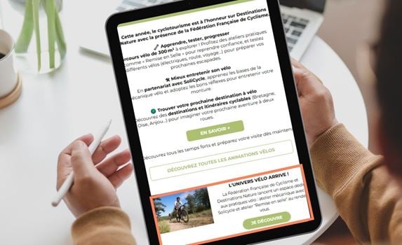 Une personne regardant sa tablette avec une newsletter Destinations Nature.