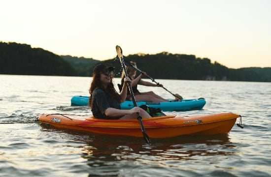Deux personnes en kayak en fin de journée sur la mer.