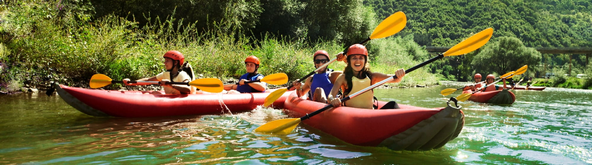 Des sportifs pagayent un canoe sur la rivière
