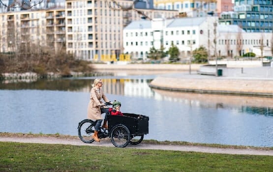 Une dame à vélo se promenant près d'une rivière.
