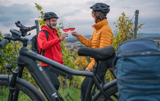 Deux cyclistes profitant de leur visite pour boire du vin.