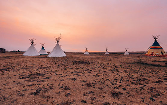 Des tentes plantées face à un coucher de soleil