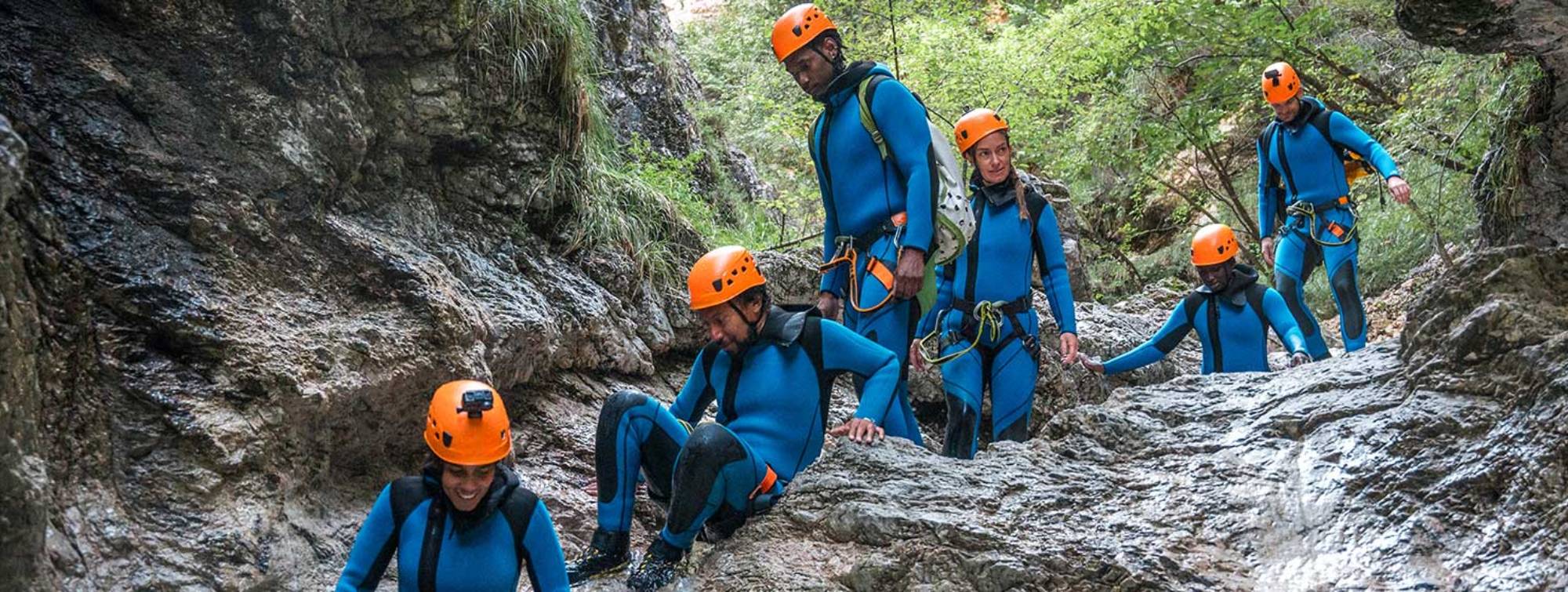 Des jeunes font du canyoning sur un courant d'eau en montagne