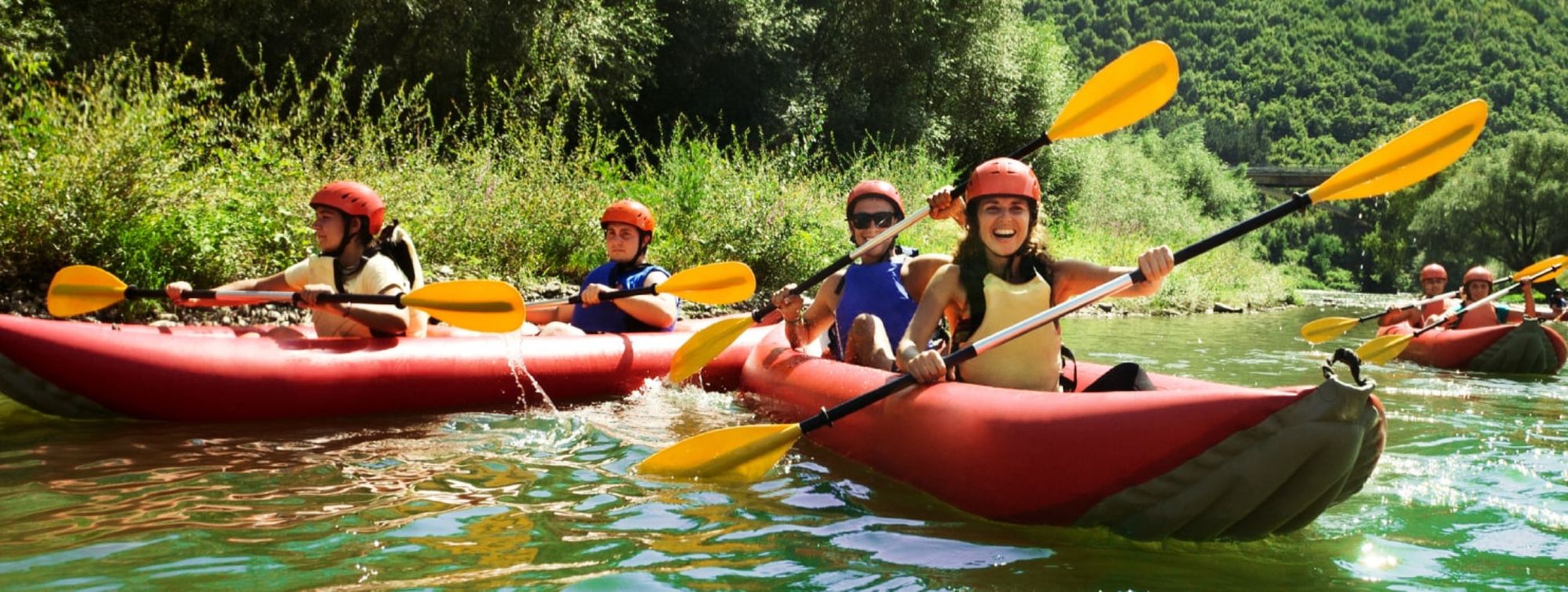 Des sportifs pagayent un canoe sur la rivière