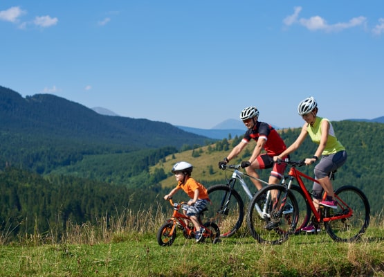 Un couple fait du vélo avec leur enfant en pleine montagne