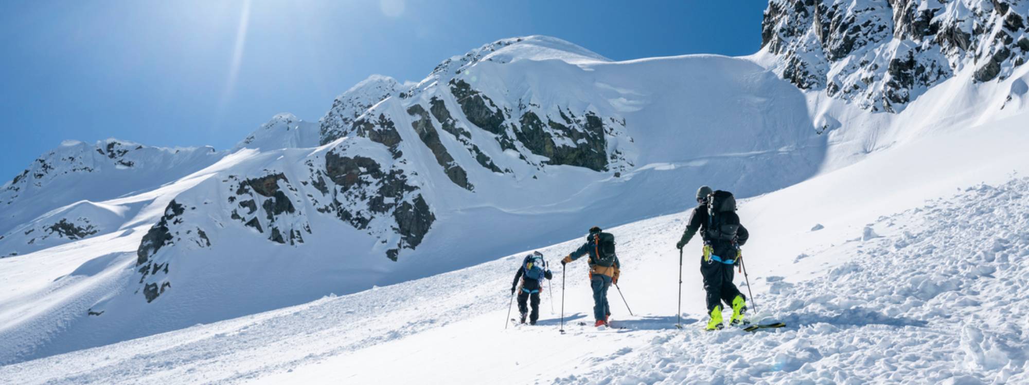 3 personnes randonnent à ski dans la montage enneigée