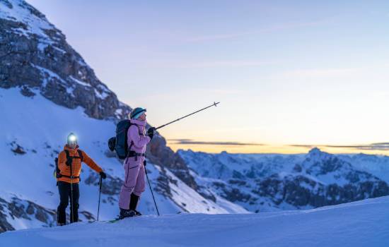 2 personnes en ski de randonnée à la tombée de la nuit