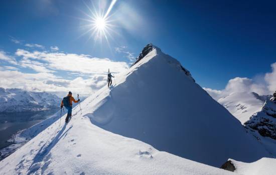 2 personnes qui randonnent à ski sur le flan d'une montagne 