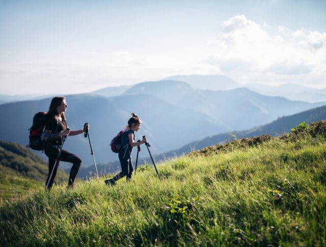 Une famille avec un enfant regardant un paysage de montagne. 