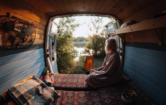 Une jeune femme dans son van regardant la vue.