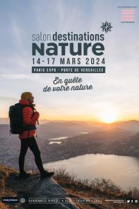 Nouvelle affiche du salon Destinations Nature qui se déroulera du 14 au 17 mars 2024 à Paris Expo, Porte de Versailles dont le slogan est "En quête de votre nature". Photo représentant une randonneuse face à un lac. 