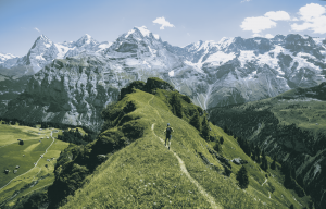 Un runner sur un chemin de montagne avec vue sur les monts